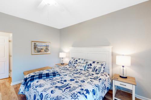 a bedroom with a blue and white bed and two lamps at Sweet Retreat in Sunset Beach
