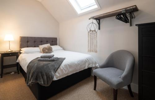 een slaapkamer met een bed en een stoel bij Taigh Carnan - 2 Huntly Terrace in Inverness