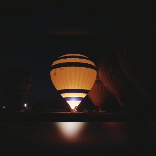 a hot air balloon is lit up in the dark at Karnak flat in Luxor