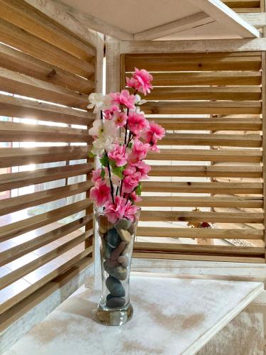 a vase filled with pink flowers sitting on a table at Oro&Mattia's House in Trapani