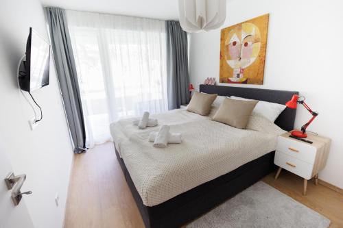 a bedroom with a large bed with toys on it at Villa Bauhaus Wellness Apartman Fsz. 3 in Siófok