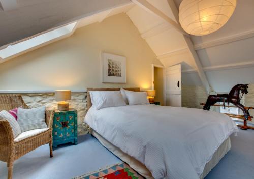 a bedroom with a large bed and a chair at The Corn Mill in Solva