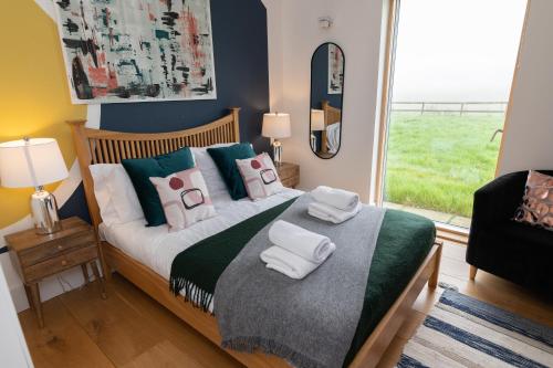 a bedroom with a bed with towels on it at A Stunning State Of The Art Eco Home - Games Room in Westhill 