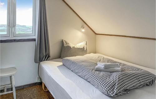 niewielka sypialnia z łóżkiem i oknem w obiekcie Beautiful Home In Offersy With Kitchen w mieście Offersøy