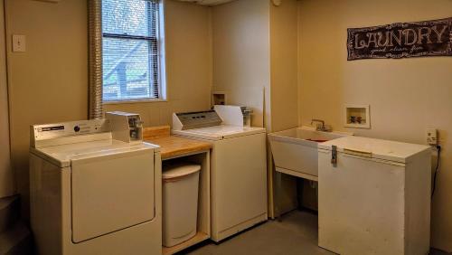a laundry room with white appliances and a counter at Casual Living Extended Stay Hotels in Algonquin