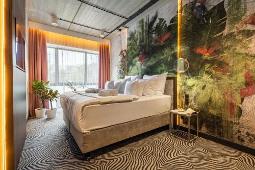 1 dormitorio con 1 cama con una pintura en la pared en Hotel Zoo by Afrykarium Wroclaw, en Wroclaw