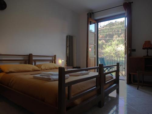 um quarto com uma cama e uma grande janela em la casa di mario em Massa