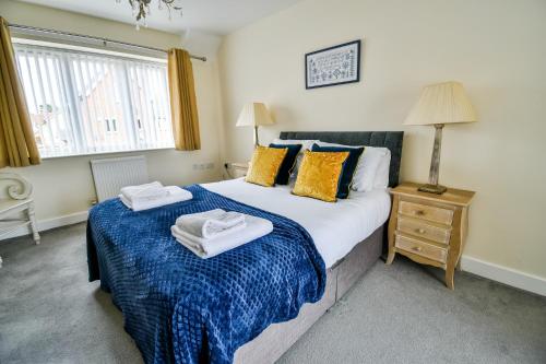 ein Schlafzimmer mit einem großen Bett mit Handtüchern darauf in der Unterkunft Beech Court House By Horizon Stays in Widdrington