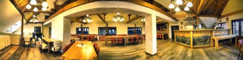 a large room with tables and chairs in a restaurant at Hotel Farma Vysoká in Chrastava