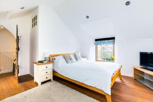 una camera con letto e televisore di Dingles Cottage a Saint Minver