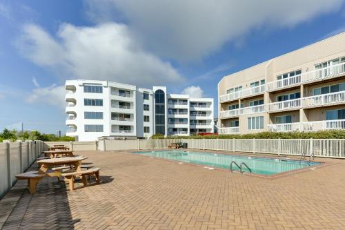 ブリゲンティーンにあるBrigantine Condo with Beach Access and Pool Viewsのプール、テーブル、建物を併設するリゾート