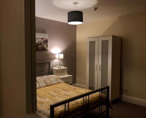 a mirror in a bedroom with a bed and a lamp at Portrush Holiday Hostel Guesthouse in Portrush
