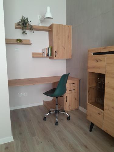 an office with a desk and a green chair at Apartament Królewiecka 54b/26 in Mrągowo