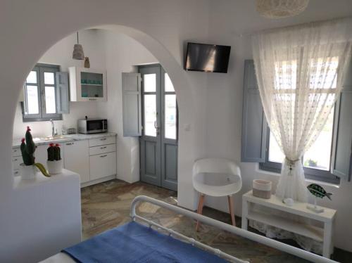 a bedroom with a bed and a kitchen with at Scarpathia House in Katapola