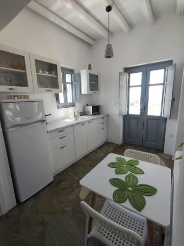 a kitchen with a white table with a green leaf on it at Scarpathia House in Katapola