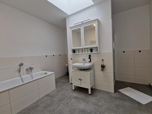 ein weißes Badezimmer mit einem Waschbecken und einer Badewanne in der Unterkunft BohnApartments - Town House am Stadtpark - gratis Parkplatz - WLAN in Erfurt