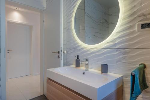 a bathroom with a white sink and a mirror at Apartment Glamorous Getaway in Zadar