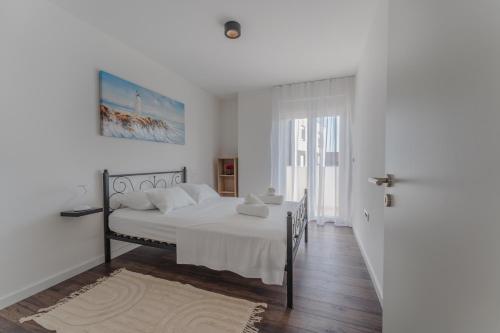 a white bedroom with a bed with white sheets at Apartment Glamorous Getaway in Zadar