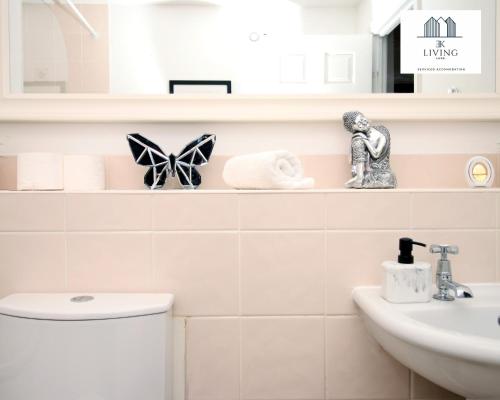 y baño con aseo y lavamanos. en Spacious 3 Bedroom Duplex Apartment On Cardiff Bay - Free Parking & WIFI By EKLIVING LUXE Short Lets & Serviced Accommodation, en Cardiff