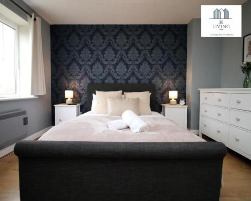 a bedroom with a large bed with a blue wall at Spacious 3 Bedroom Duplex Apartment On Cardiff Bay - Free Parking & WIFI By EKLIVING LUXE Short Lets & Serviced Accommodation in Cardiff