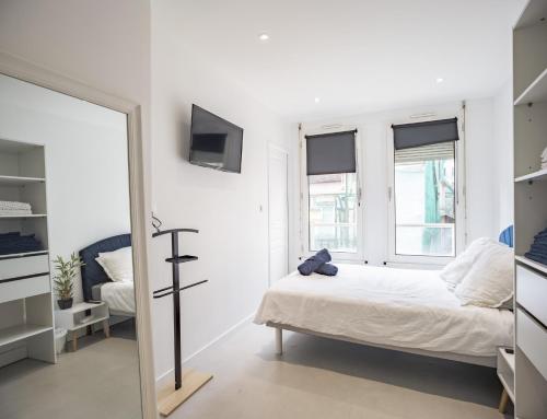 Habitación blanca con cama y espejo en White Croco - Confort & Central en Troyes