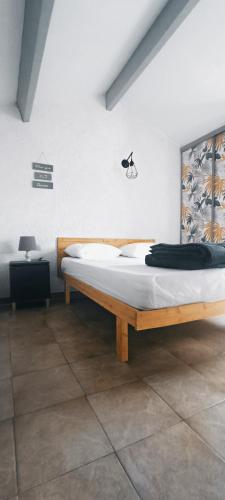 a bedroom with a wooden bed in a room at Gite la Capelle près de la réserve Africaine de Sigean et Narbonne à 10 min des plages in Roquefort-des-Corbières
