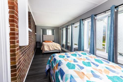 1 dormitorio con 1 cama y ventanas en The Gorge View Villa- With Private Yard & Free Parking-see full listing info, en Niagara Falls