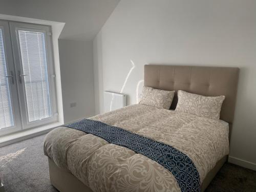 a bedroom with a large bed and a window at Eaglet luxury home in Manchester