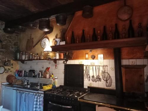 a kitchen with a stove and many bottles on the wall at Morelli House in Montalbo