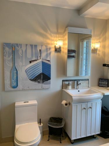 a bathroom with a toilet and a sink and a mirror at L'Authentique in Orford