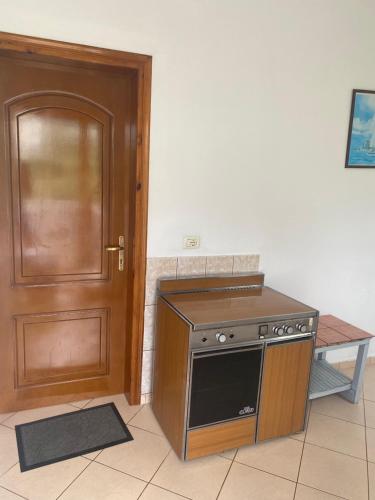a kitchen with a stove and a wooden door at Rexhos Studios in Himare