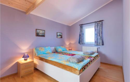 a bedroom with a bed with a night stand and a window at 2 Bedroom Gorgeous Apartment In Peroj in Peroj
