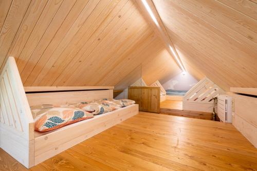 een kamer met een bed op een zolder met houten plafonds bij Apartmány U 3 Zbujů in Malenovice