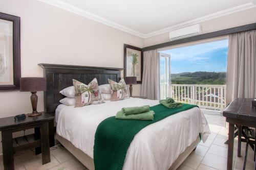 a bedroom with a bed with a view of a balcony at At 4 Umzumbe Beach Apartment, Mangrove Beach Estate in Melville