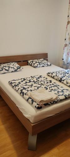 a bed with a wooden frame with a bedspread on it at Apartman Fran in Zagreb