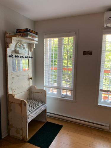a room with a bench in a room with windows at L'Authentique in Orford