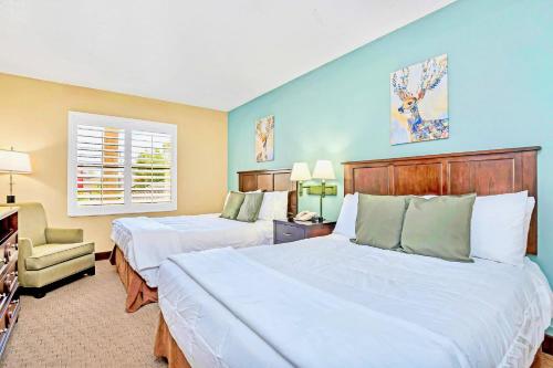 a hotel room with two beds and a chair at Family Friendly 1BR Suite with Swimming Pool - Near Disney in Orlando