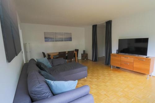 a living room with a couch and a flat screen tv at Appartment am Ziegelwasen in Kirchheim unter Teck