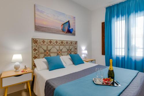 1 dormitorio con 1 cama y bandeja con una botella de vino en NottInCentro -Guest House-, en Sciacca