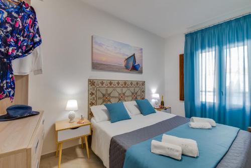a bedroom with a large bed with blue accents at NottInCentro -Guest House- in Sciacca