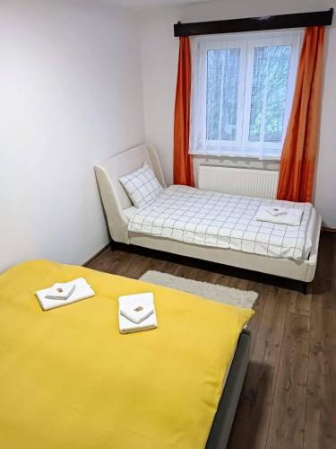 a bedroom with a bed and a couch and a window at Lend City Apartment in Miercurea-Ciuc