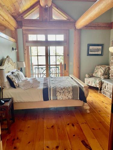 a bedroom with a large bed and a large window at Oneida Lodge North in Cooperstown