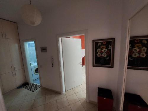 a hallway with a white door and a washing machine at Redsun City Center Apartment in Vlorë