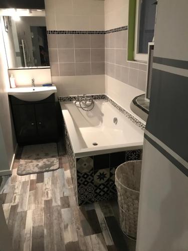 une salle de bain avec une baignoire et un lavabo dans l'établissement Maison piscine proche La Rochelle, à Salles-sur-Mer