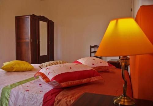 a bedroom with a bed with a lamp on a table at Casas da Boa Vista in Horta
