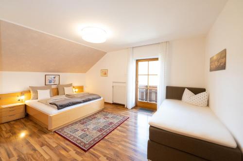 1 dormitorio con 2 camas y sofá en Ferienwohnungen Lanserhof, en Appiano sulla Strada del Vino