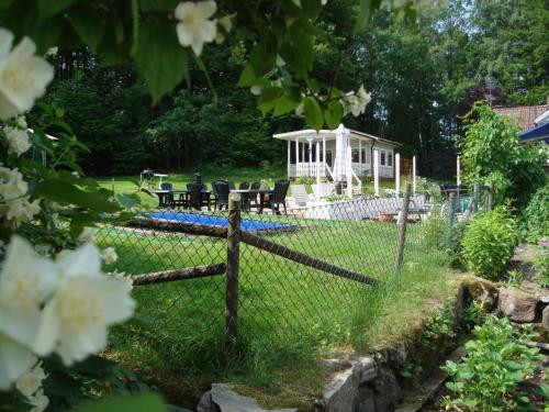 a fence in front of a yard with a house at Möllegården Bed & Breakfast in Tyringe