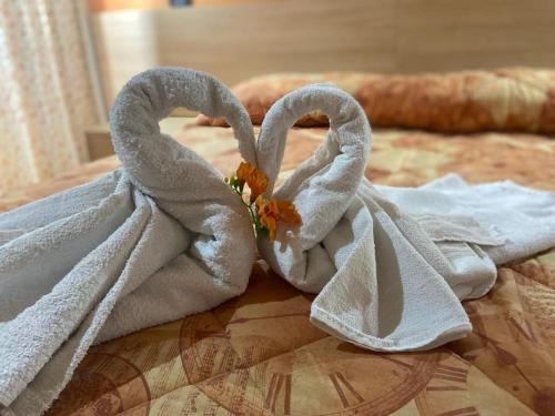Dos toallas con forma de corazón sentadas en una cama en MANDANICI :Borgo Marsalini, en Barcellona-Pozzo di Gotto
