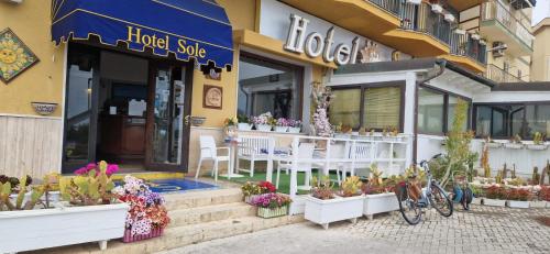 a flower shop with tables and chairs in front of it at Hotel Sole in Gela