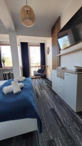 1 Schlafzimmer mit einem blauen Bett und einer Küche in der Unterkunft White Beach 211 in Mielno